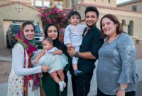 Family standing in front of house